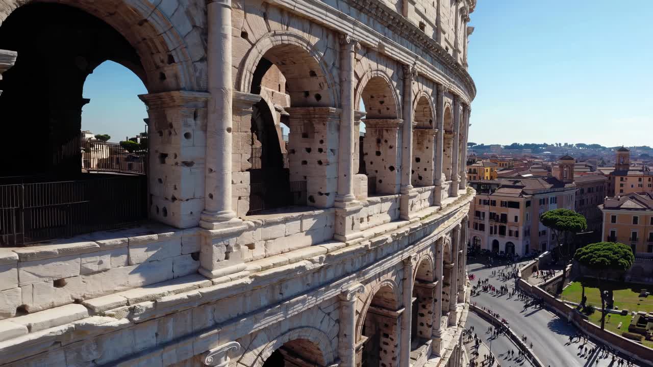 Aerial video captures the ancient Colosseum's grandeur from a side angle, showcasing its arches