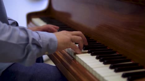 Varón-Caucásico-En-Ropa-Informal-Inteligente-Chapado-En-Madera-Vintage-Manos-De-Piano-Cerca-De-Fondo-Borroso-Cámara-Lenta