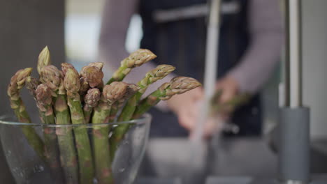 woman's hands wash asparagus