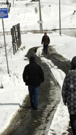 personas caminando por un camino de campo nevado