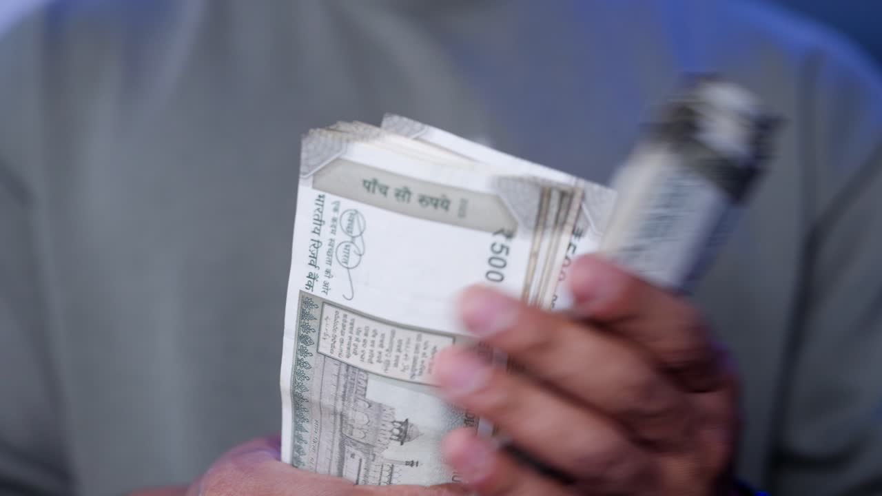 Close-Up of Men's Hands Holding Indian Rupee Notes — Financial Planning and Cash Management in India