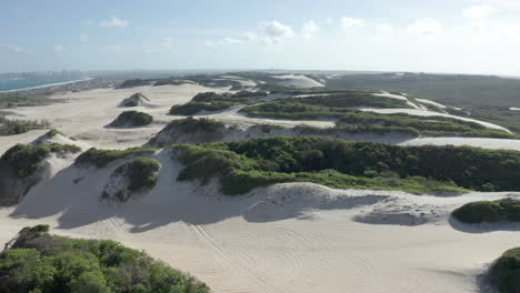 aerial - beautiful sandy dunes on genipabu beach, brazil, rising reveal tilt down