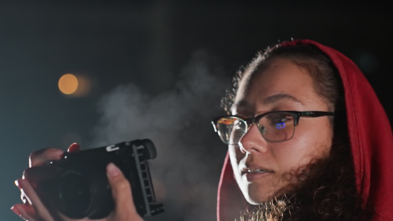 Yökuvaus tähtivalokuvaus, jossa tähdet näkyvät yläpuolella, naisvalokuvaaja nostaa DSLR-kameran taivasta kohti, säätää valotusta ja tarkennusta, tarkistaa esikatselun näytöltä, itsevarma keskittyminen, hienovarainen reuna-valo