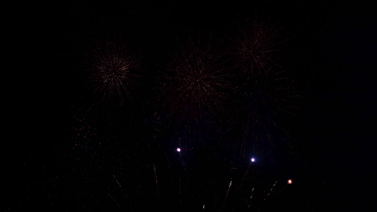 Tons of tiny fireworks explode in the dark sky