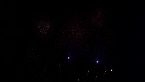 toneladas de pequeños fuegos artificiales explotan en el cielo oscuro