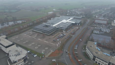 aerial of office building on busy industrial terrain in foggy weather