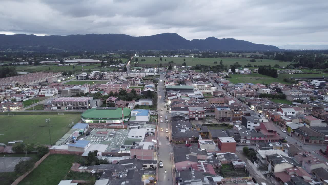Drone zoom in towards Tenjo, Colombia, showing rooftops, streets and surrounding countryside