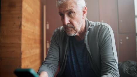 man using smartphone in locker room