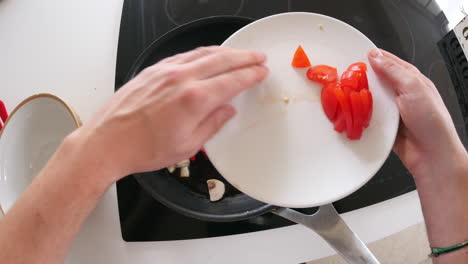 point of view of man cooking vegetables in a pan