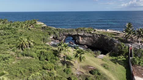 Drone-flying-towards-stone-arch-at-La-Hondonada-coast-in-Samana-Peninsula,-Dominican-Republic