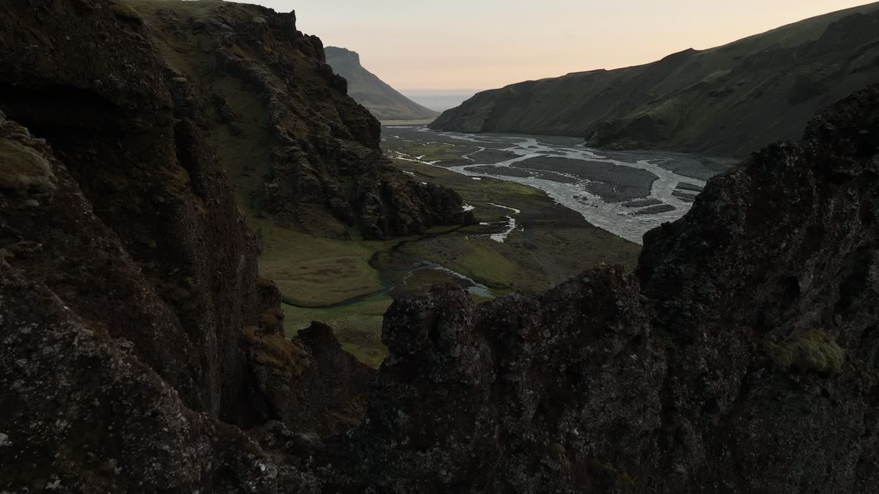 A dramatic revealing view of rugged cliffs and winding river in northern Iceland, showcasing the untouched, remote beauty of the valley landscape.