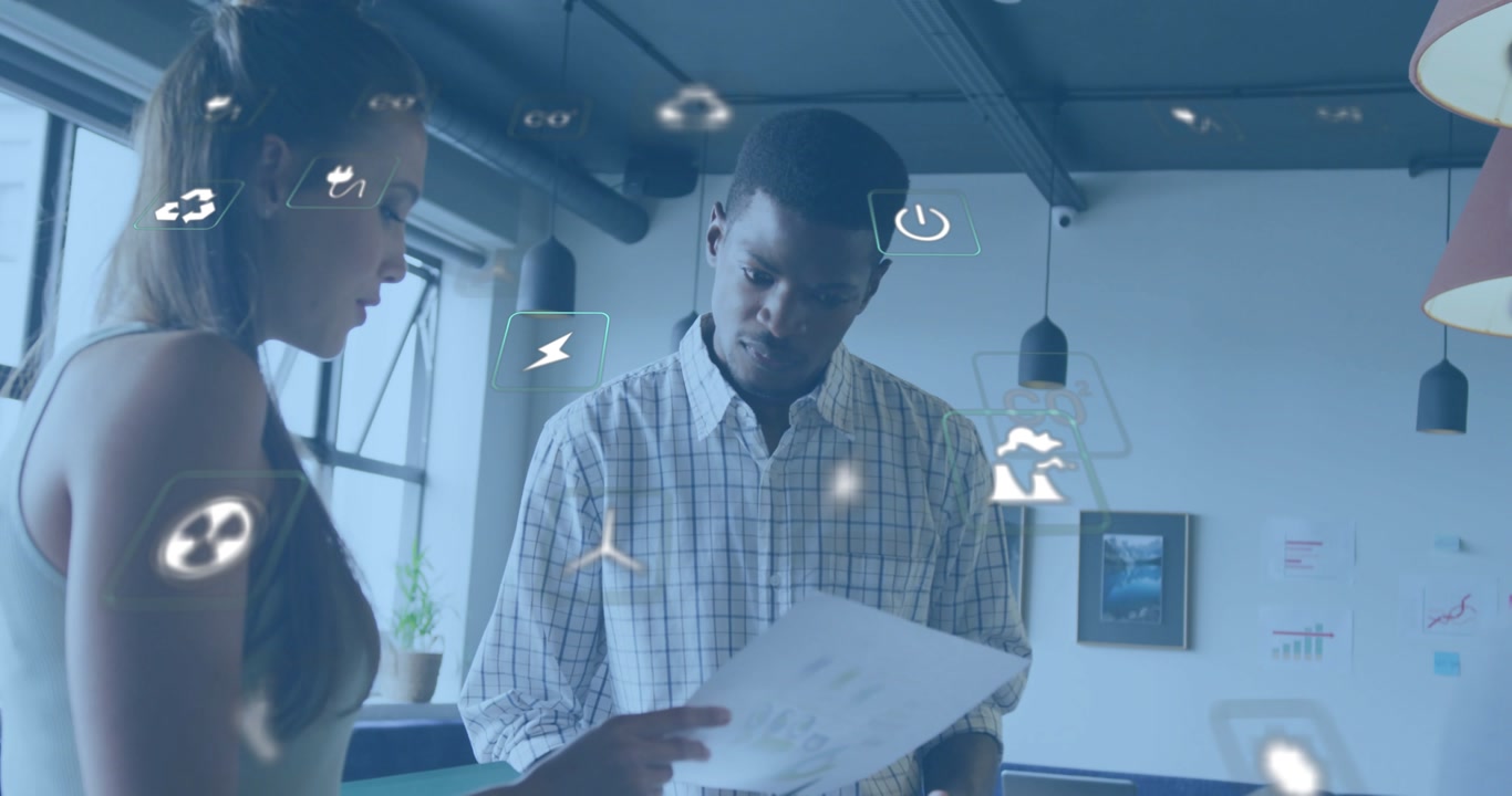 Junior colleague handing chart to colleague in office, analyzing eco data with floating AR icons