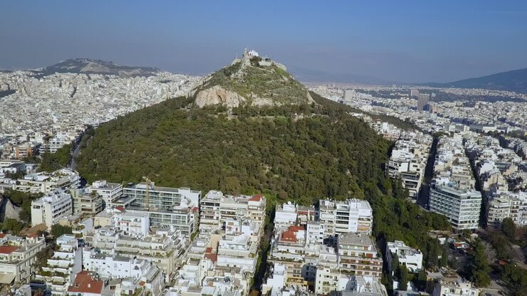 Ampia ripresa aerea soleggiata in orbita del Monte Licabetto, Atene, Grecia, 4K
