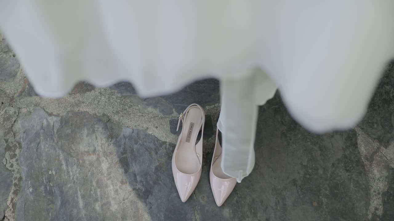 zapatos de boda que aparecen debajo del vestido
