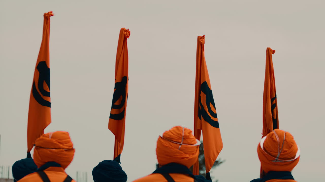 Bandiere Sikh della religione indiana tenute da guardie durante il Vaisakhi.