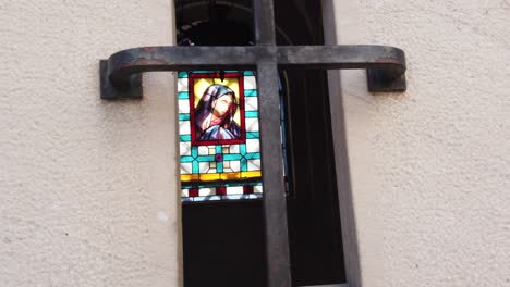 catholic vitreaux stained glass in the background of cemetery mausoleum closeup