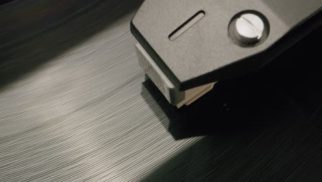 primer plano de una aguja de reproductor de discos en un disco de vinilo