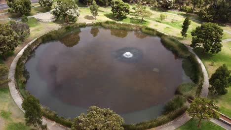 órbita-Aérea-Lenta-Alrededor-Del-Pintoresco-Lago-Circular-Con-Fuente-Central