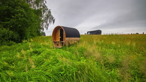 tiro estático de cabina rectangular y sauna de barril con hierba verde cortada por máquina cortadora de hierba durante la primavera en timelapse