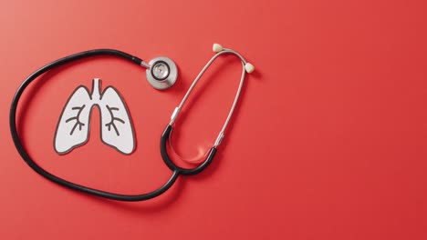 video of close up of stethoscope with lungs on pink background