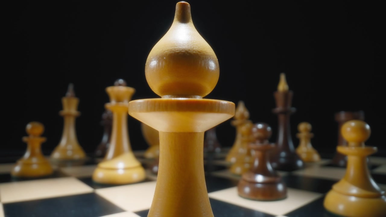 Macro dolly shot of a white bishop chess piece on a chessboard