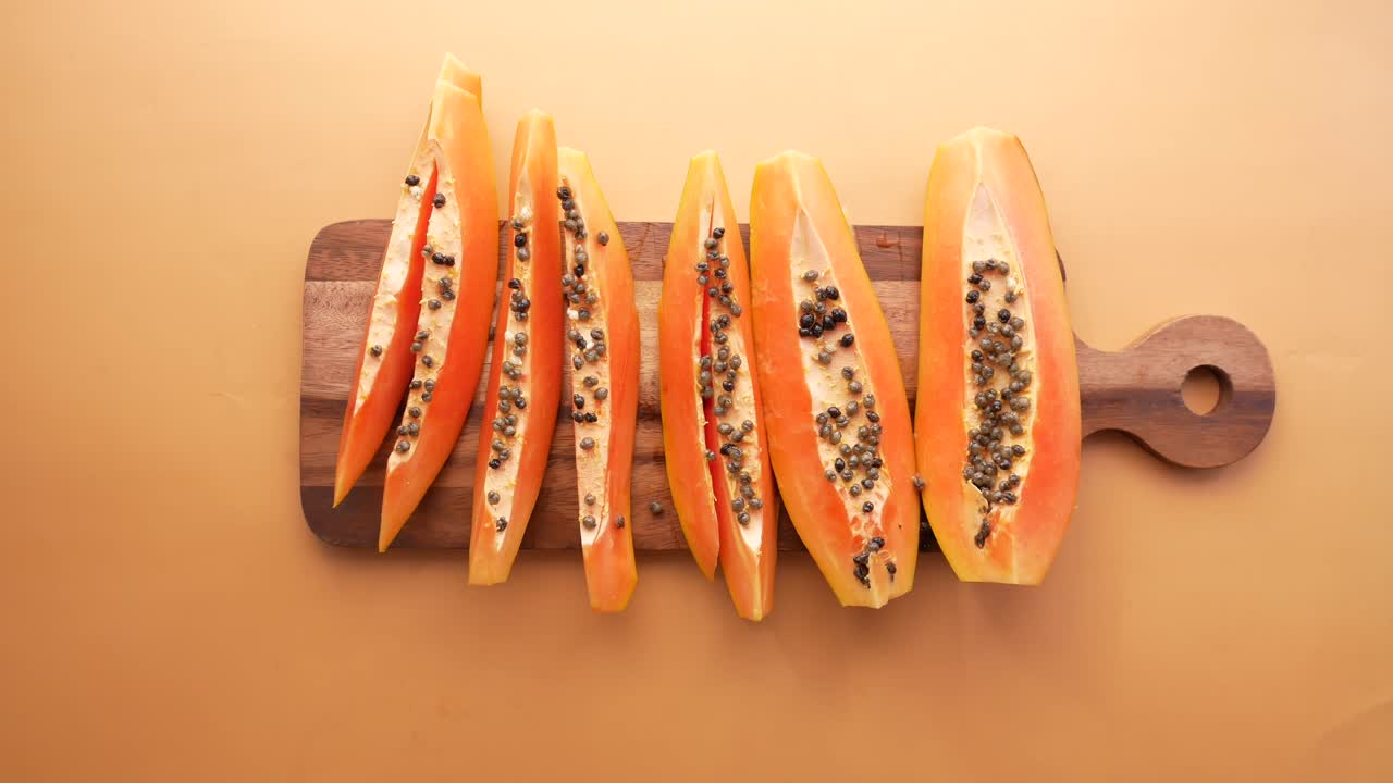 papaya en rodajas en una tabla de cortar de madera