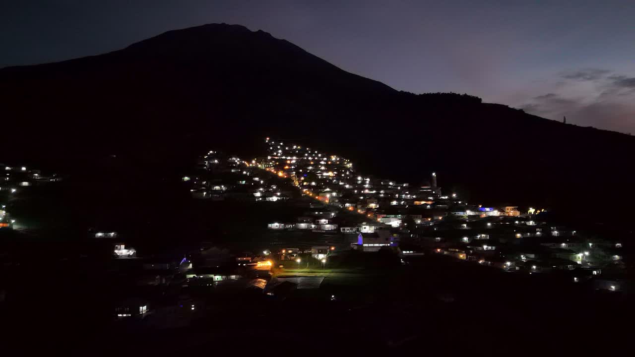 vista aérea de las luces de las casas en las aldeas en las laderas de la montaña en el amanecer nebuloso de la mañana