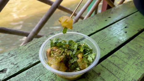 sampling spicy squid dish at bangkok market