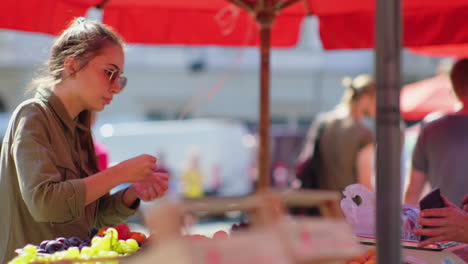 woman buying fruit at an outdoor market