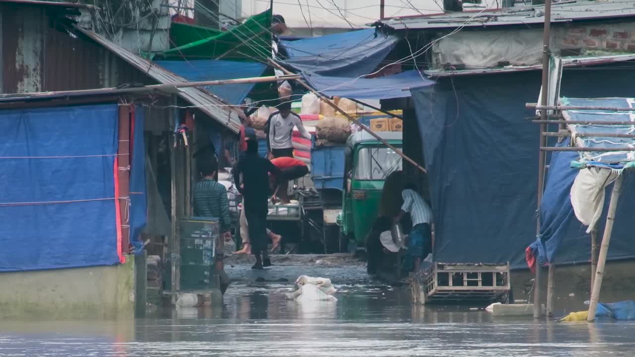 Laborers Are Loading Goods On Truck at a Flooded Market by the River in Bangladesh, South Asia - Static Shot