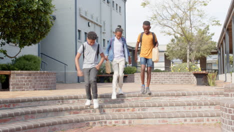 walking outside school, multiracial students carrying backpacks and chatting happily