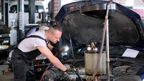a male mechanic working on a car in an auto repair shop