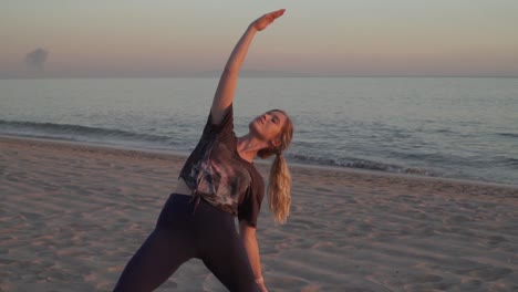 female blonde doing yoga pose on the beach