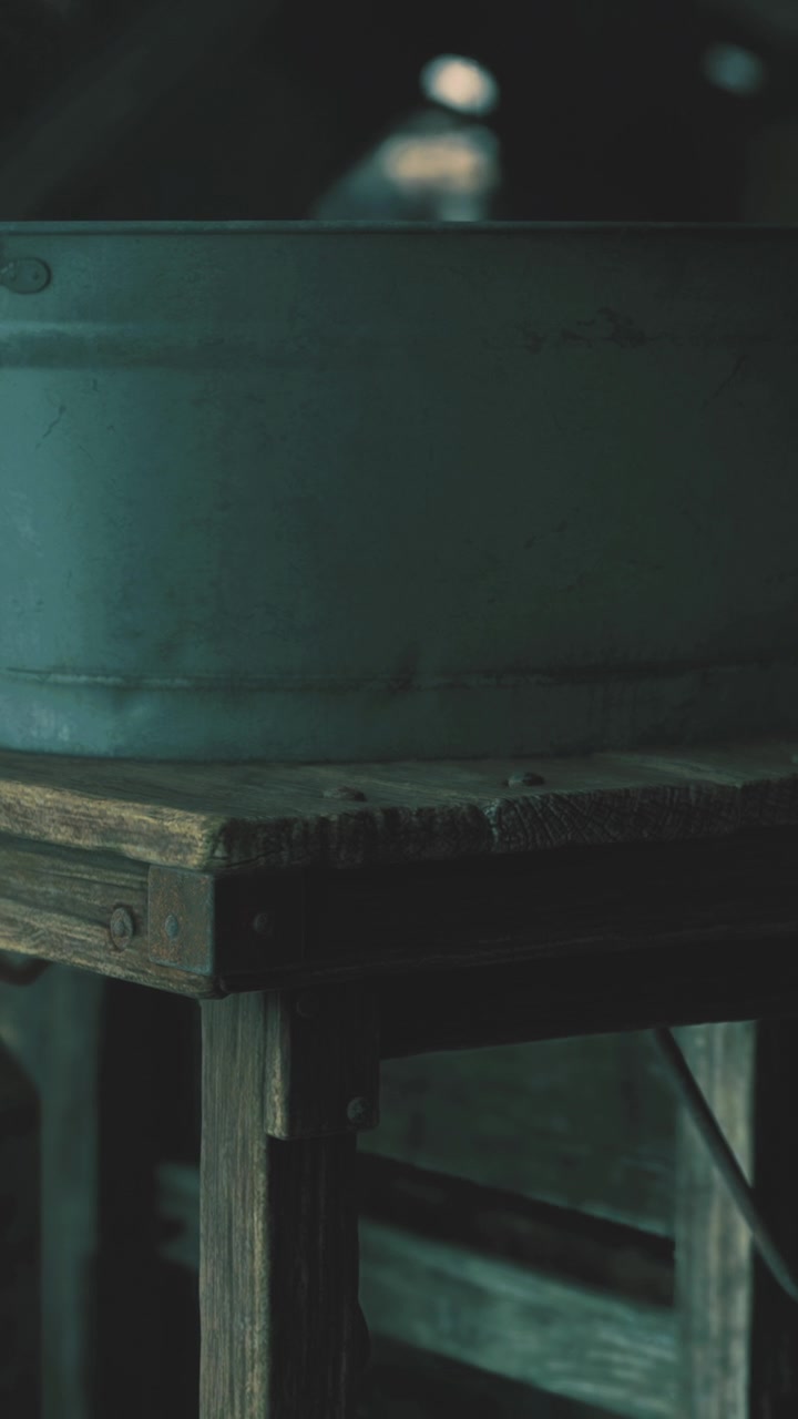 Vecchio lavabo su tavolo di legno in una stanza in penombra in una località rurale di giorno.