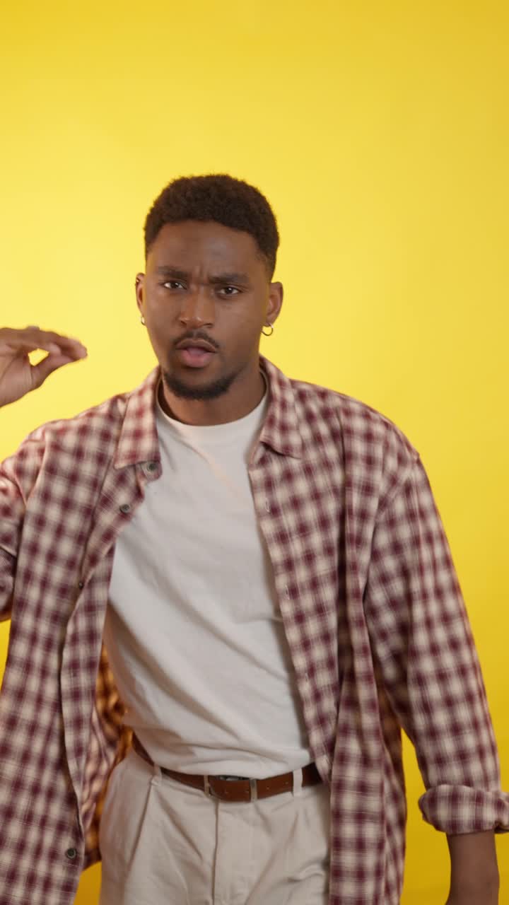 Man in plaid shirt on yellow background