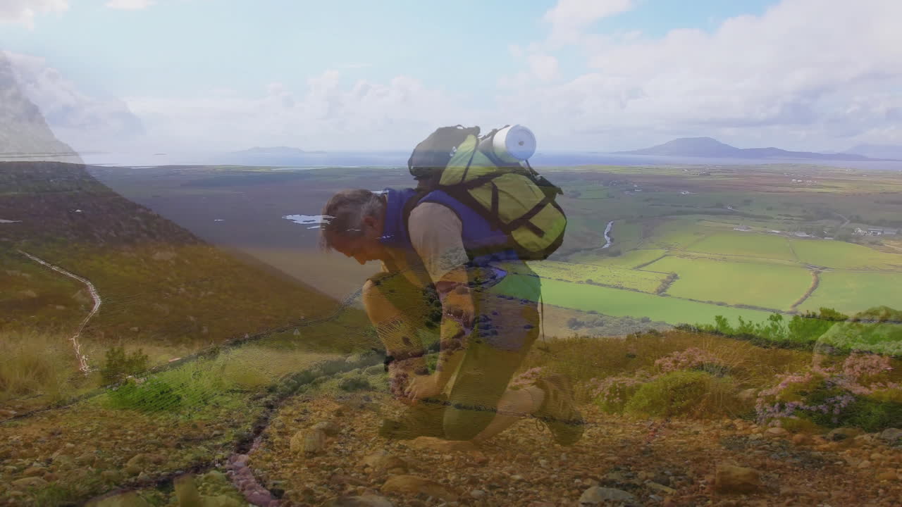 male hiker kneeling tying boot on mountain slope, showing animated route map for travel planning