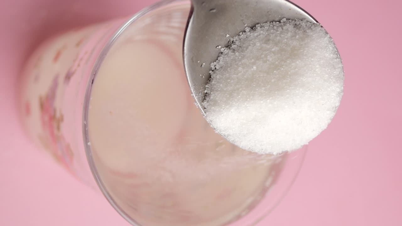 Close-up of a spoon stirring a drink in a glass