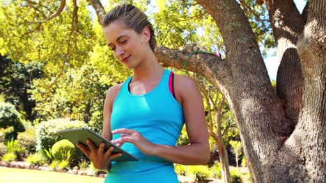 woman using digital tablet in park