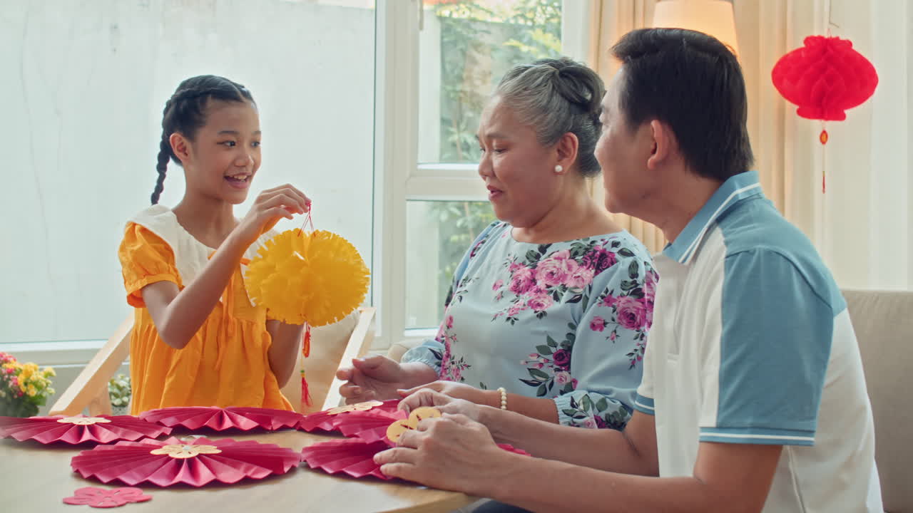 Multi-generational Asian Family Members Making Decorations for Lunar New Year