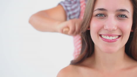 Happy-woman-sitting-while-her-hair-is-being-brushed