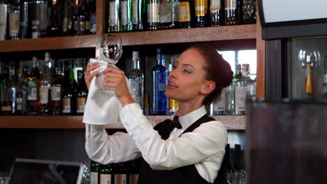 una bonita camarera limpiando una copa de vino