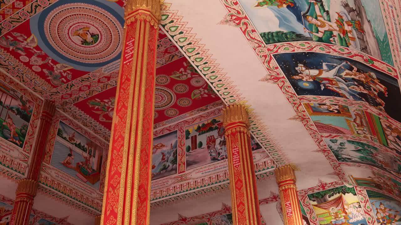 Dipinti religiosi colorati all'interno del Tempio Buddista Stupa d'Oro Pha That Luang a Vientiane, Laos