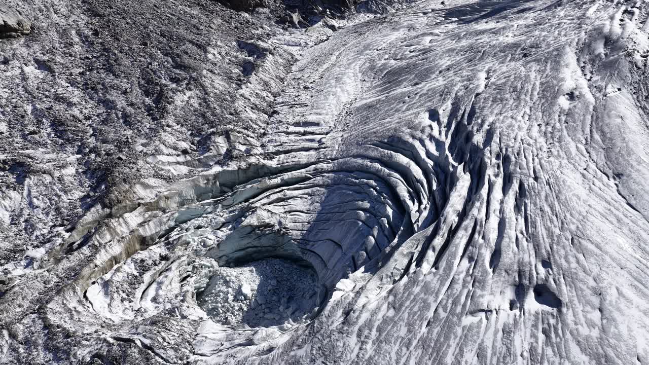 Detailed aerial of deep crevasses and ice folds on Morteratsch Glacier. Graubünden, Switzerland
