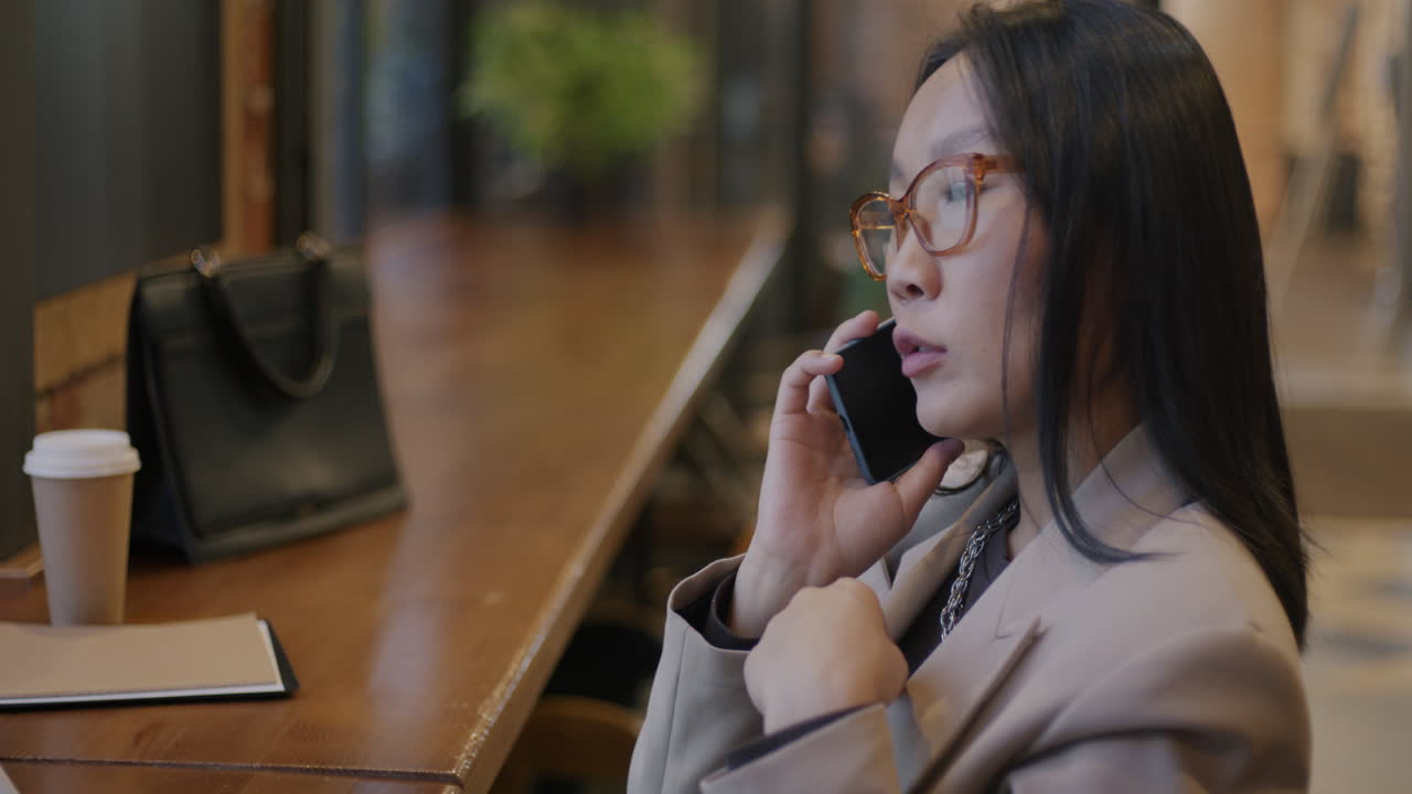 Businesswoman on Phone Call in Coffee Shop