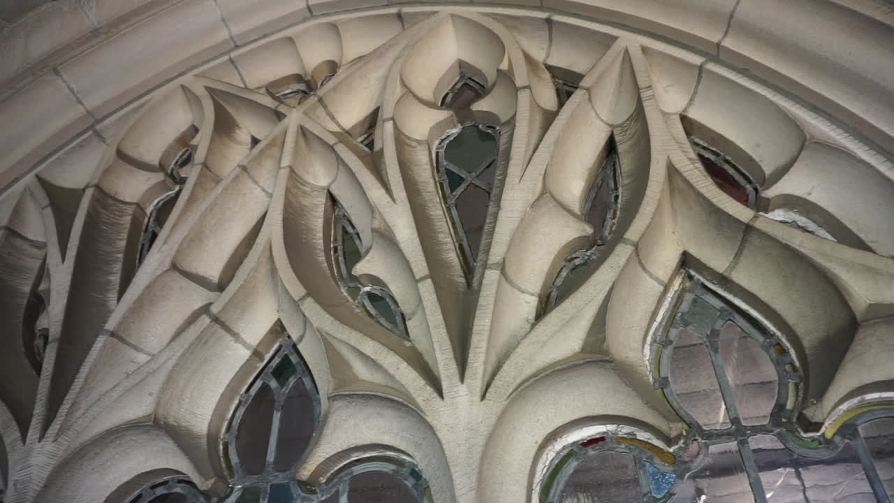 Camera pans left to right over leaded glass window and tracery