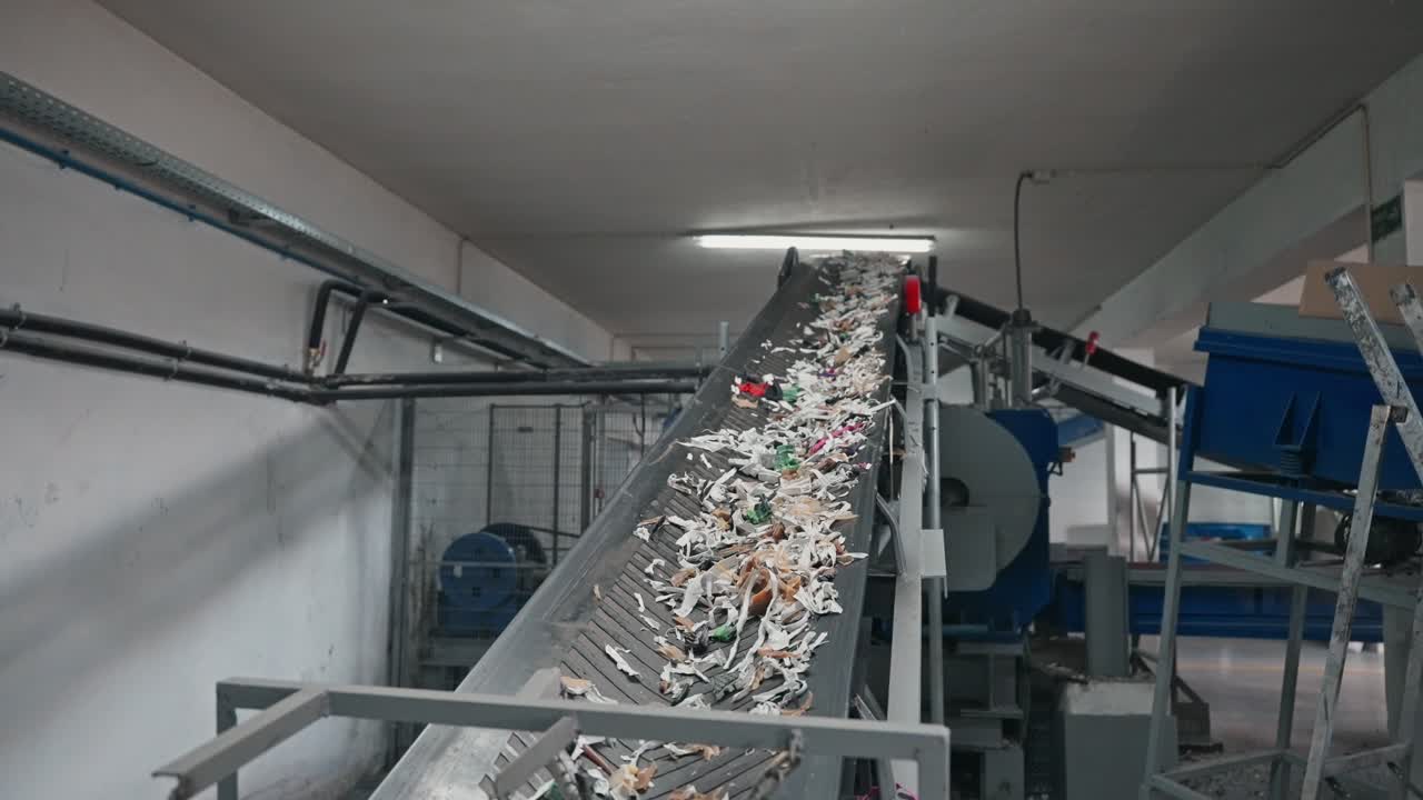 shredded waste fragments transported on inclined factory conveyor