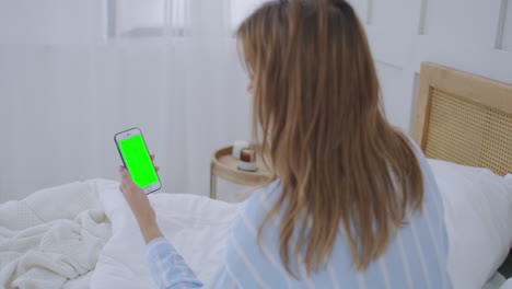 Schöne-Frau-Mit-Smartphone-Touchscreen-Display-Im-Hellen-Raum.-Junge-Attraktive-Brünette-Frau-Spricht-Morgens-Per-Videoanruf-über-Die-Smartphone-Webcam-Mit-Einer-Freundin-Im-Schlafzimmer