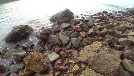 las olas golpean una playa rocosa en la laguna azul en port dickson, malasia