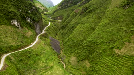 hermoso camino sinuoso tallado en un hermoso y exuberante valle verde en el paso de ma pi leng en el norte de vietnam