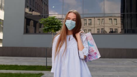 Teenager-girl-with-multicolor-shopping-bags-wearing-protect-mask.-Black-Friday-during-coronavirus